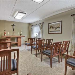 A serene chapel with simple wooden seating and religious symbols.