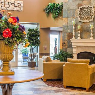 A cozy lobby with elegant decor, featuring a floral arrangement and a welcoming seating area.