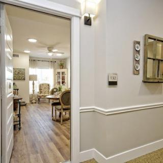 A view from the hallway leading into a warmly lit living space, featuring modern decor and wooden flooring.