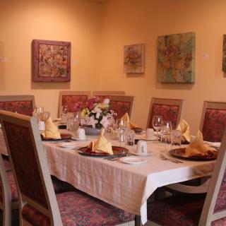 A beautifully set dining table in a restaurant with elegant decor and wall art.