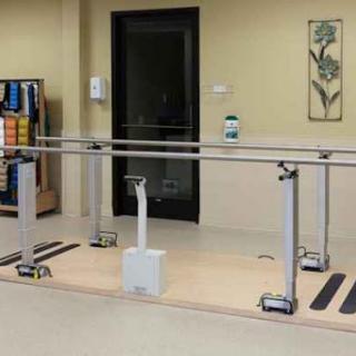 A set of parallel bars in a physical therapy room designed for rehabilitation exercises.
