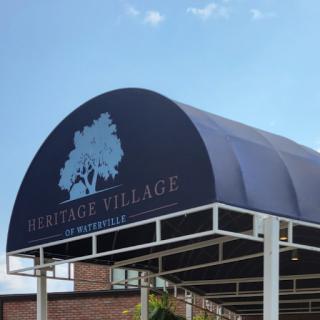 Entrance sign for Heritage Village, featuring a distinctive canopy design.
