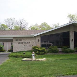 A view of the front entrance of a facility named 'Southern Village' surrounded by well-maintained lawn and landscaping.