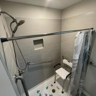 Accessible shower with grab bars and a shower chair.