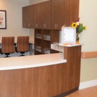 A modern reception area with wooden furniture and sunflowers in a vase.