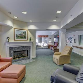 A cozy living room with a fireplace and various comfortable chairs, creating an inviting seating area.