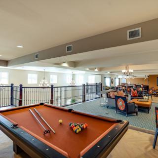 A spacious game room featuring a pool table, seating area, and recreational space.