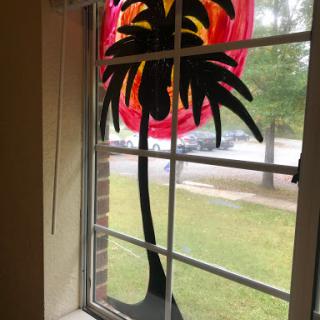 A vibrant palm tree window decoration adds a tropical touch to the indoor space.