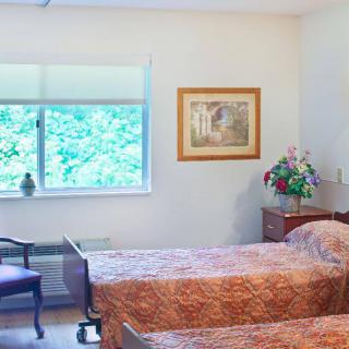 A cozy bedroom with twin beds, a window view, and elegant decor.
