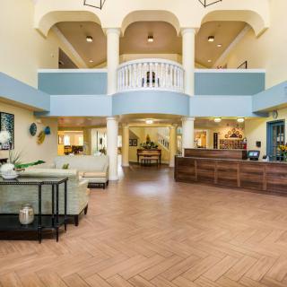 Spacious and elegantly designed lobby with a central reception desk, comfortable seating, and stylish decor.
