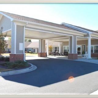 A covered entrance to a facility with a circular driveway.