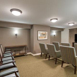 A small conference room with rows of chairs and ceiling lights, ready for a meeting or presentation.