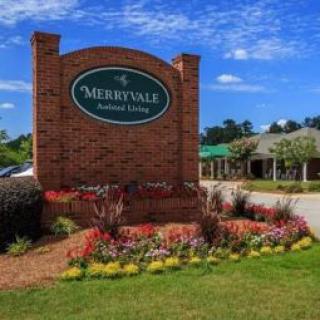 A brick entrance sign surrounded by vibrant flowers.