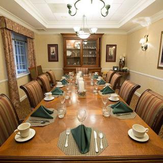 A formal dining room with an elegantly set table and a chandelier.