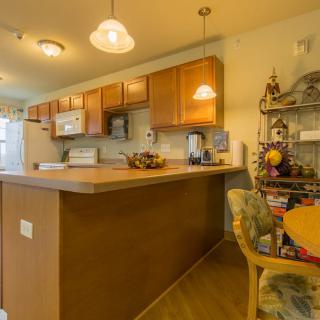 A warm and inviting kitchen with wooden cabinets, a spacious countertop, and cozy lighting.
