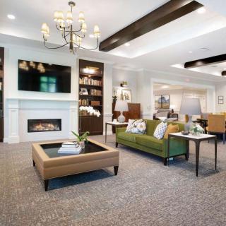 A modern living room featuring a fireplace, elegant chandelier, and comfortable seating.