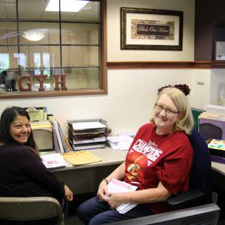 Two women enjoying a moment at their office workspace.