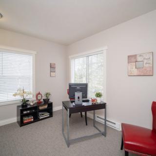 A bright and minimalist home office with a desk, chair, and computer, accented by decorative items.