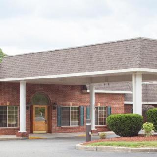 A brick building with a covered entrance and white columns.