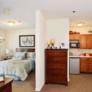 A cozy studio apartment featuring a bedroom area and a compact kitchen.
