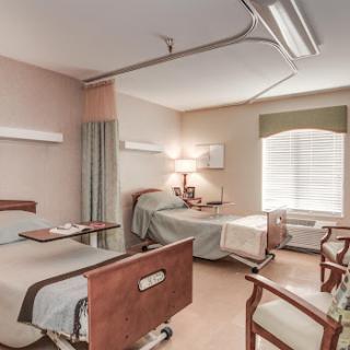 A spacious and well-lit hospital patient room designed for comfort and care.