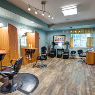 A modern hair salon featuring stylish chairs, wooden accents, and bright lighting.