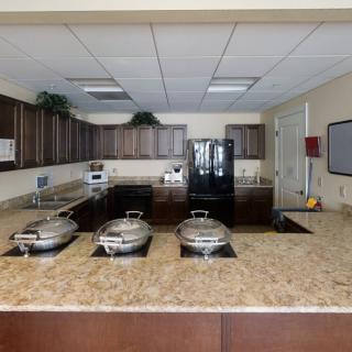 A modern kitchen with a granite countertop and cooking appliances.