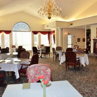 Elegant dining room with a chandelier and red accents.