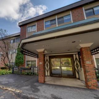 A view of a residential building entrance with brick facade and a covered entryway.