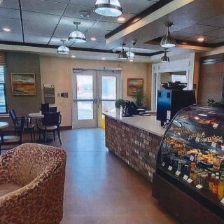 A cozy cafe interior with seating and a display case.
