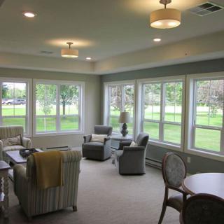 A cozy living room with ample natural light and comfortable seating arrangements.