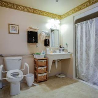 A clean and organized bathroom with a toilet, sink, and shower.