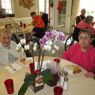 Elderly individuals enjoying a meal together in a dining area.