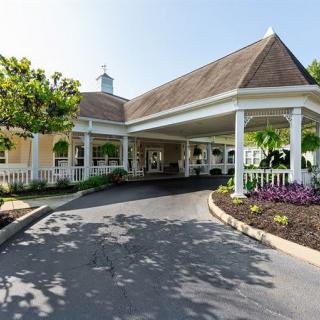 A welcoming view of a building entrance with a covered driveway and landscaped surroundings.