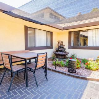 A cozy outdoor patio with a table, chairs, and a garden fountain.