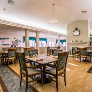A spacious and well-lit dining area with elegantly arranged tables and chairs.