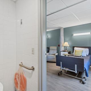 A view into a modern hospital patient room, featuring a clean shower area and comfortable furnishings.
