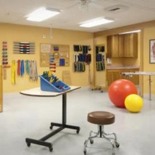 A physical therapy room equipped with various exercise tools and therapy balls.