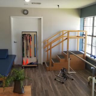 A well-equipped rehabilitation room featuring therapy stairs and exercise equipment for patient use.