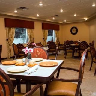 A cozy dining room interior with neatly arranged tables and chairs.