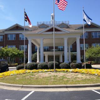 The elegant entrance of a hotel showcasing multiple flags.