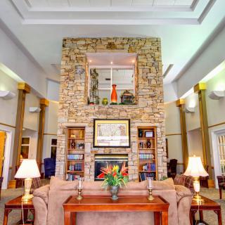 A cozy living room with a large stone fireplace, elegant decor, and comfortable furniture.