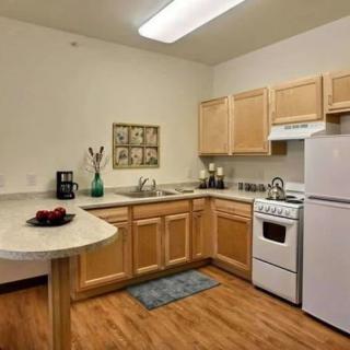A modern kitchen with wooden cabinets, white appliances, and a countertop.