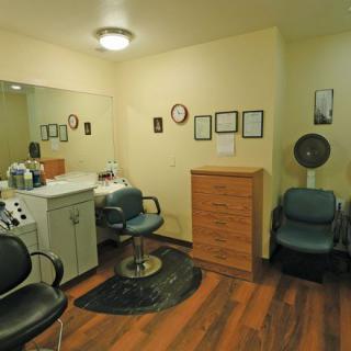 A cozy hair salon interior with chairs and a styling station.