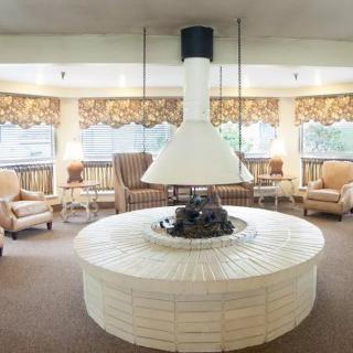 A vintage-style lounge with a central fireplace and cozy seating arrangement.