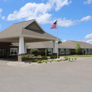 A building entrance with a flagpole and an American flag on a clear day.