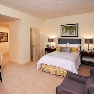 A cozy hotel room with a neatly made bed, bedside lamps, and elegant decor.