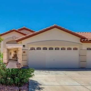 A beautiful residential house featuring a two-car garage and a landscaped front yard.