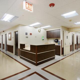 A clean and organized hospital hallway with a central reception desk.