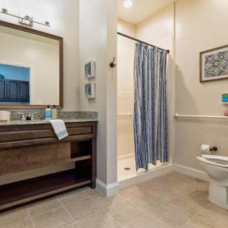 Modern bathroom with a vanity sink, shower, and toilet.